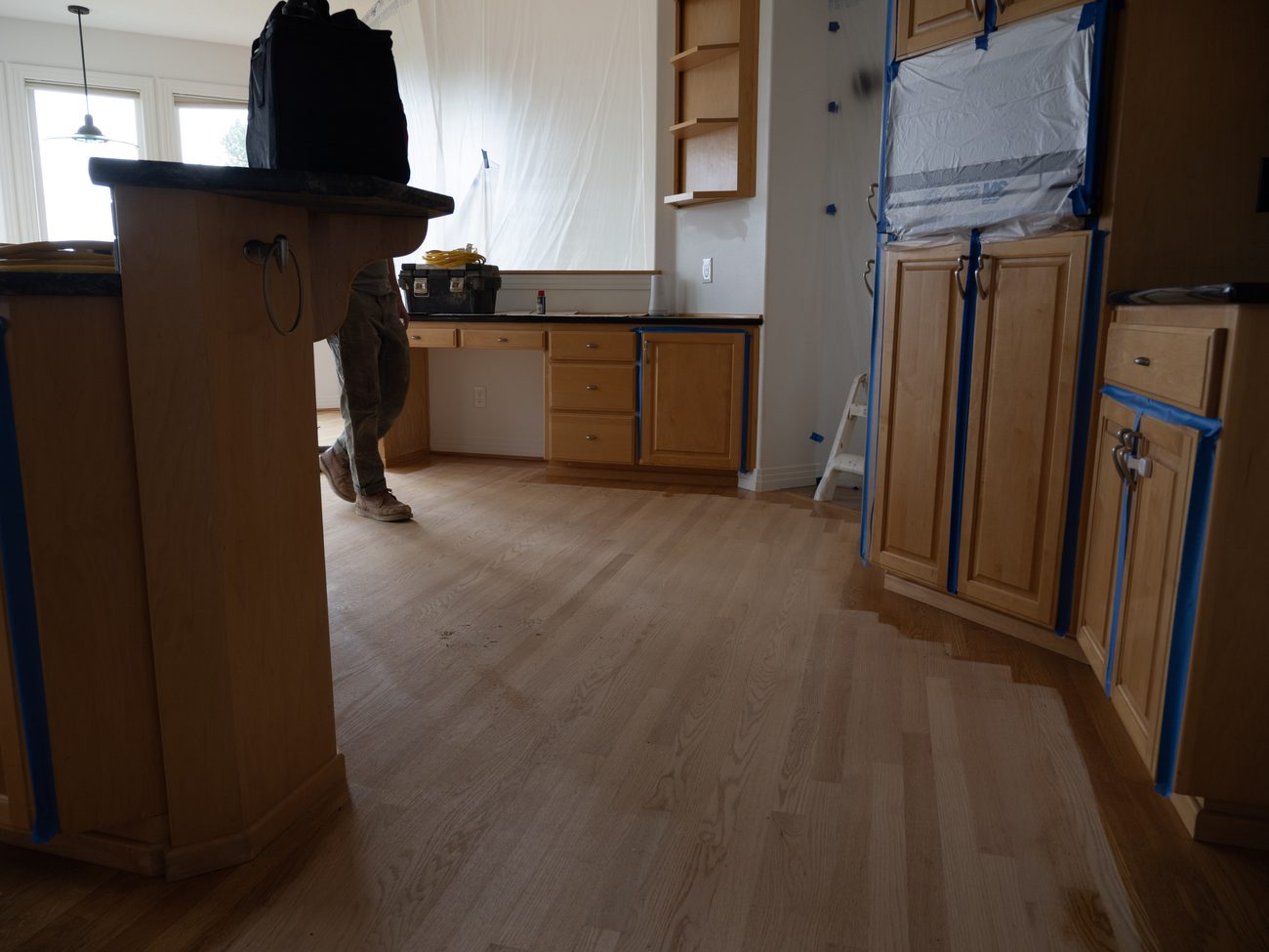 Kitchen sealed off with plastic sheeting and tape to contain sanding dust